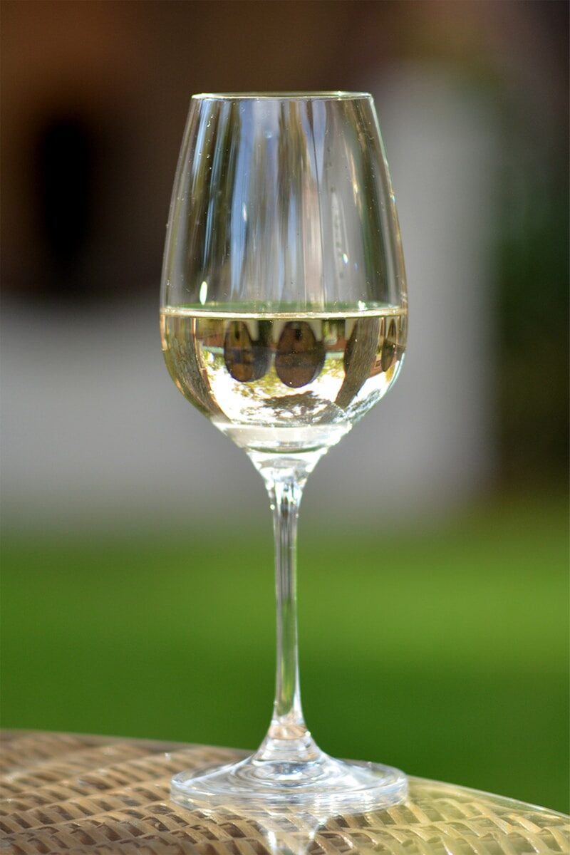 a glass of wine sitting on top of a table